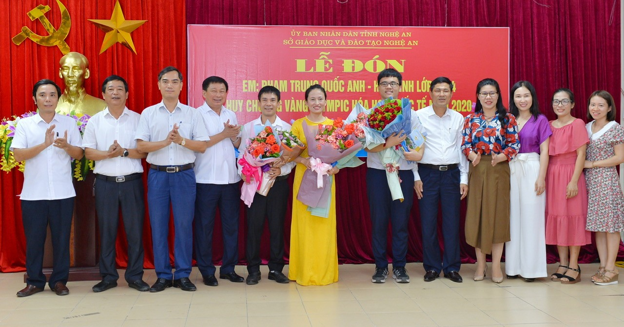 A group of people standing in front of a red banner

Description automatically generated