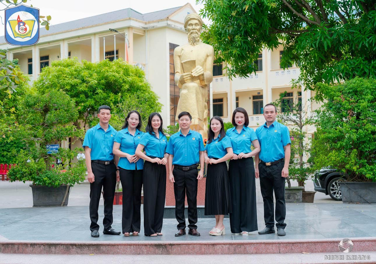 A group of people standing in front of a statue

Description automatically generated