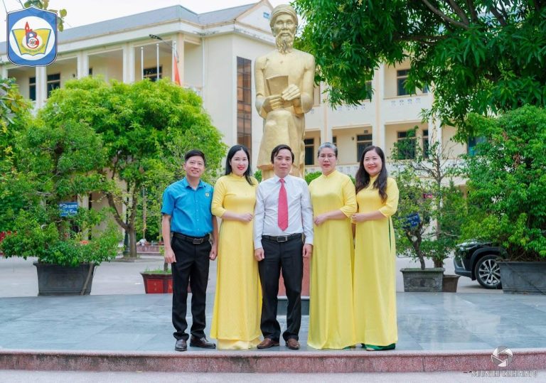 A group of people standing in front of a statue Description automatically generated