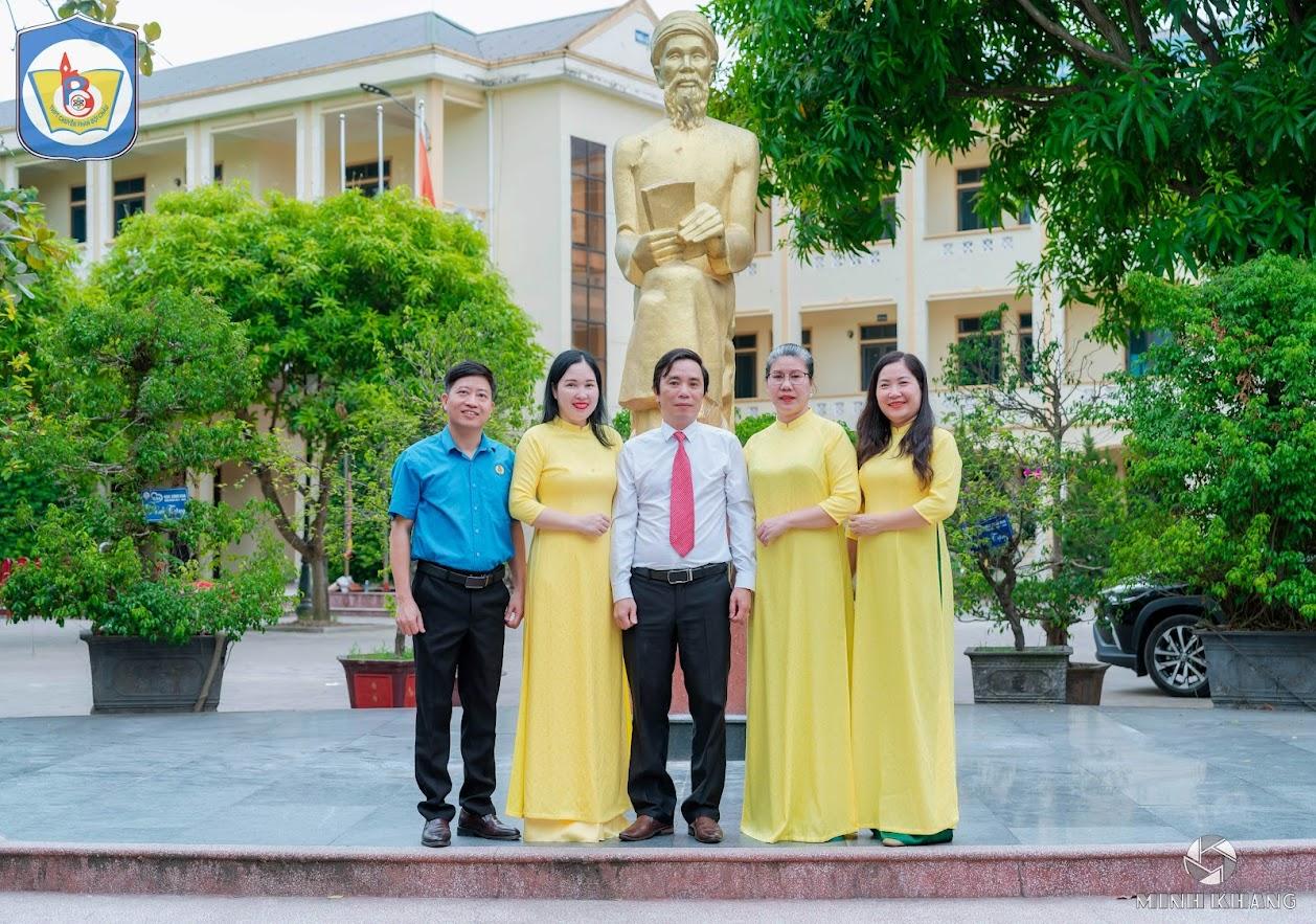 A group of people standing in front of a statue

Description automatically generated