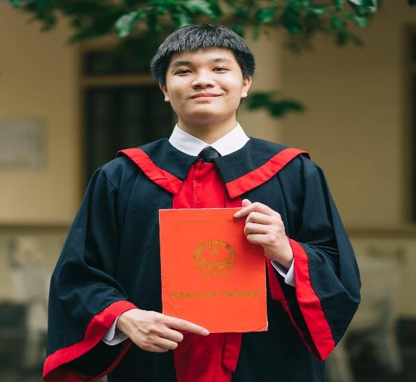 A person in a black and red robe holding a red book

Description automatically generated